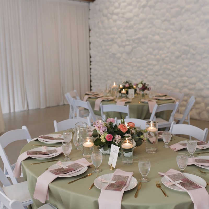 Wedding centerpiece on a table with white chairs
